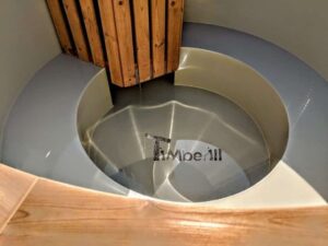 TimberIN Nordic Flex – primo piano della vasca interna grigia in polipropilene con panca sagomata, zona piedi rotonda e protezione in legno della stufa