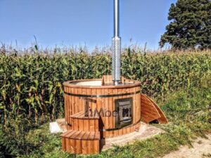 TimberIN Nordic Flex con vasca interna in polipropilene, camino in acciaio inox della stufa a legna e panche in legno su un prato