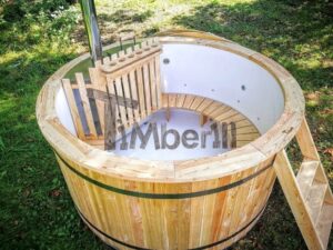 TimberIN Nordic Flex aperta su un prato, con vasca interna bianca, panca perimetrale in legno, protezione della stufa, camino e scaletta