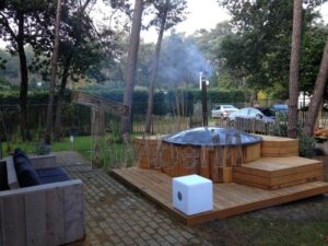 TimberIN Nordic InGround Comfort incassata in una terrazza in legno con schermatura, in giardino