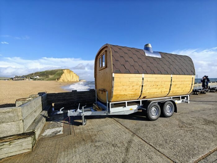 Sauna a botte mobile su un rimorchio a doppio asse vicino al mare