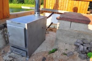 Stufa a legna esterna TimberIN Nordic External installata accanto a una vasca idromassaggio su terrazza