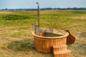 TimberIN Nordic Flex in legno termotrattato – vista frontale con camino in acciaio inox della stufa a legna e scaletta in legno