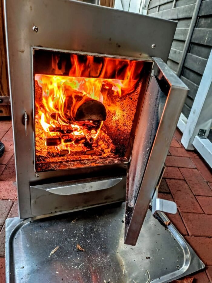 Fuoco acceso nella stufa a legna in acciaio inox di una vasca idromassaggio