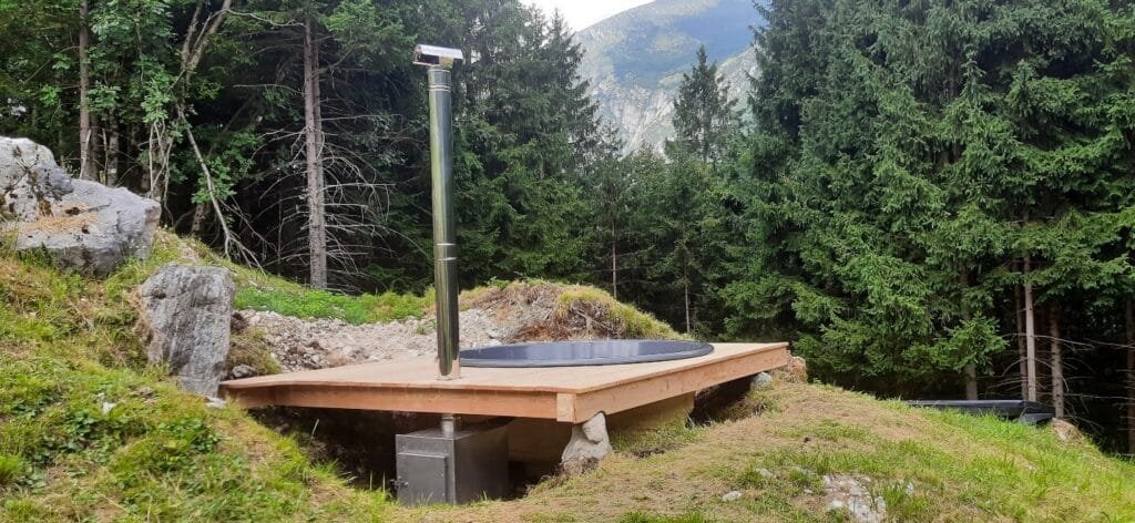 Stufa a legna esterna accanto alla vasca incassata