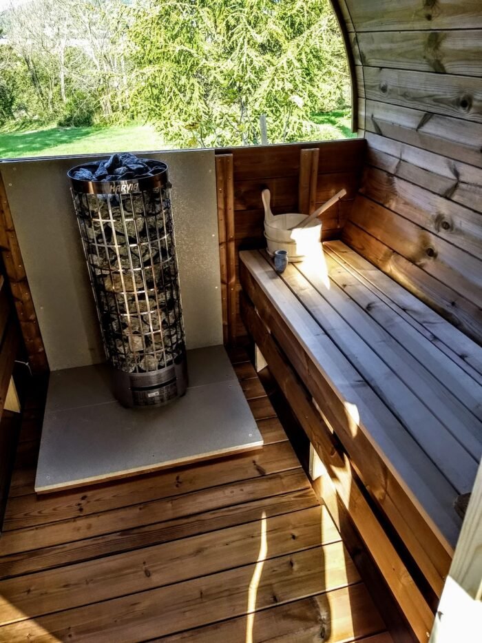 Interno di sauna finlandese con stufa elettrica a pietre e panche in legno