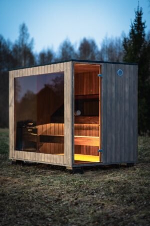 Sauna da giardino TimberIN Nordic Cube con fronte in vetro al crepuscolo