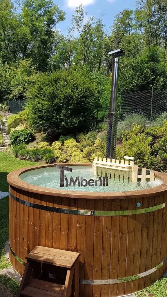 Vasca idromassaggio rotonda in un giardino con aiuole fiorite