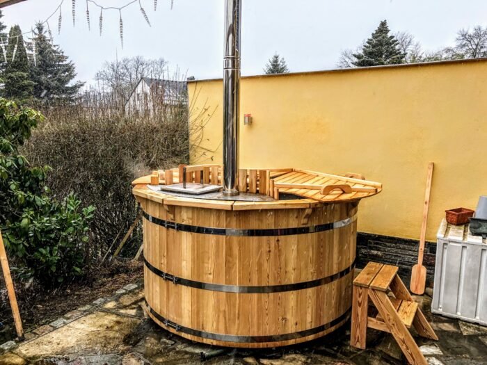 Tinozza in legno con cerchiature e camino in un giardino