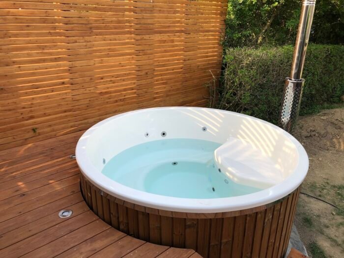 Vasca idromassaggio con vasca interna bianca e rivestimento in legno su una terrazza